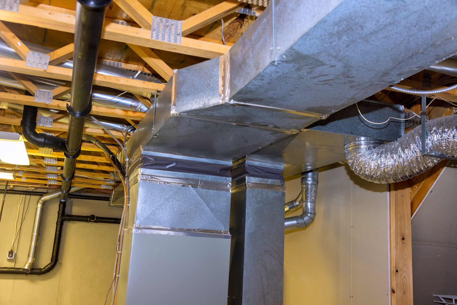 Ductwork installation in residential basement showcasing metal HVAC system components
